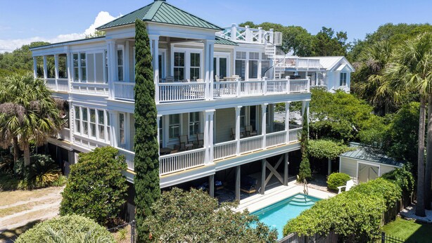 A two-story house with a balcony, a pool, and lush greenery. - Private Pool + Rooftop Ocean Views (Isle Of Palms)