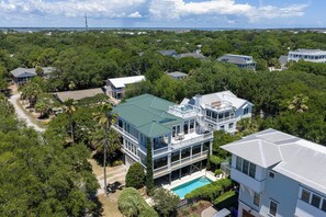 A multi-story house with a pool, surrounded by dense greenery and other residential buildings. - Private Pool + Rooftop Ocean Views (Isle Of Palms)