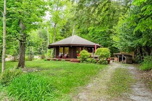 A wooden cabin with a porch, surrounded by lush greenery and trees. - Welcome to our cottage🥰 (Tiny)