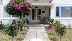 Ein Haus mit Veranda, einer Bank und einem Weg zum Eingang.