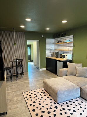 A modern living room with a sofa, a coffee table, and a patterned rug. - Cozy bungalow in Central Phoenix near stadiums, hospitals, & restaurants (Phoenix)