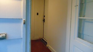 A narrow hallway with a door at the end, a window on the right, and a door on the left. - Just You Vacation Home - Main floor use (Gilbert Plains)