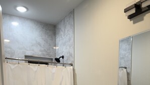 Um banheiro com cortina de chuveiro, vaso sanitário, pia e espelho.