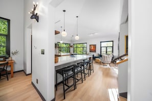 A modern kitchen with a central island, bar stools, pendant lighting, and a deer head wall decoration. - Luxury Remodeled 4BR Telluride Home | Hot Tub, Walk to Gondola & Main St | Sleeps 12 (Telluride)