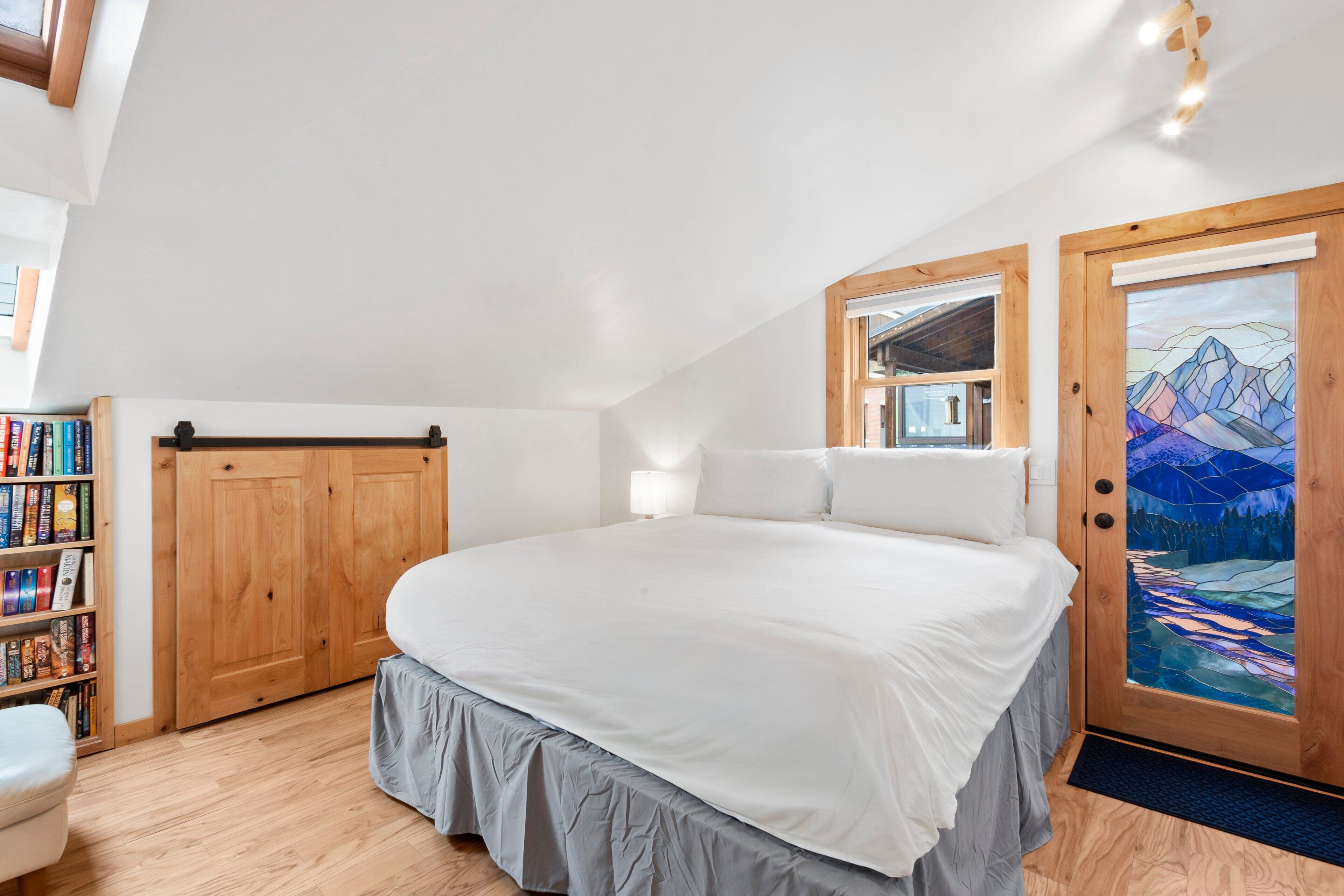 Une chambre à coucher avec un grand lit, une armoire en bois et une bibliothèque.