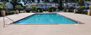 A rectangular swimming pool with a metal ladder, surrounded by a paved deck. - Delightful 2-bedroom condo with AC in Myrtle Beach (Myrtle Beach)
