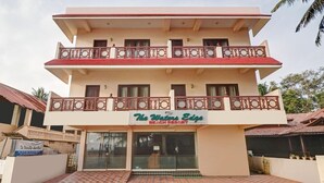 Um edifício de vários andares com uma placa indicando 'The Waters Edge Beach Resort'.