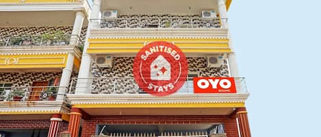 A building with a sign indicating 'Sanitised Stays' and 'Oyo Rooms'.