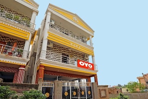 A multi-story building with balconies, a prominent 'OYO' sign, and a gated entrance. - 16363 Advik Cottage (Bhubaneshwar)