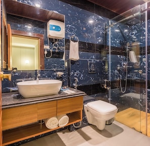 A modern bathroom with a large sink, a toilet, a glass-enclosed shower, and a marble-tiled wall. - Udaan Hotels Alpine Resort, Gangtok (Gangtok)