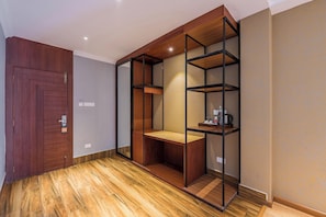 Ein Zimmer mit Holztür, einer eingebauten Regallösung und einer Wand mit Muster.