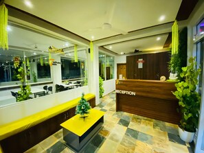 A reception area with a wooden desk, a small Christmas tree, and a check-in counter. - 7 Monkey Hills Resort By Spicy Mango (Paud)