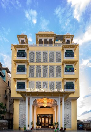 A hotel with a traditional architectural style, featuring multiple balconies and intricate lattice work. - The Chronicles Hotel (Udaipur)