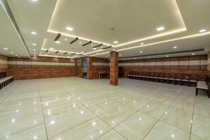 A spacious hall with a polished tile floor, recessed lighting, and a seating area with wooden benches. - Hotel Anmol Bandhan (Jaipur)