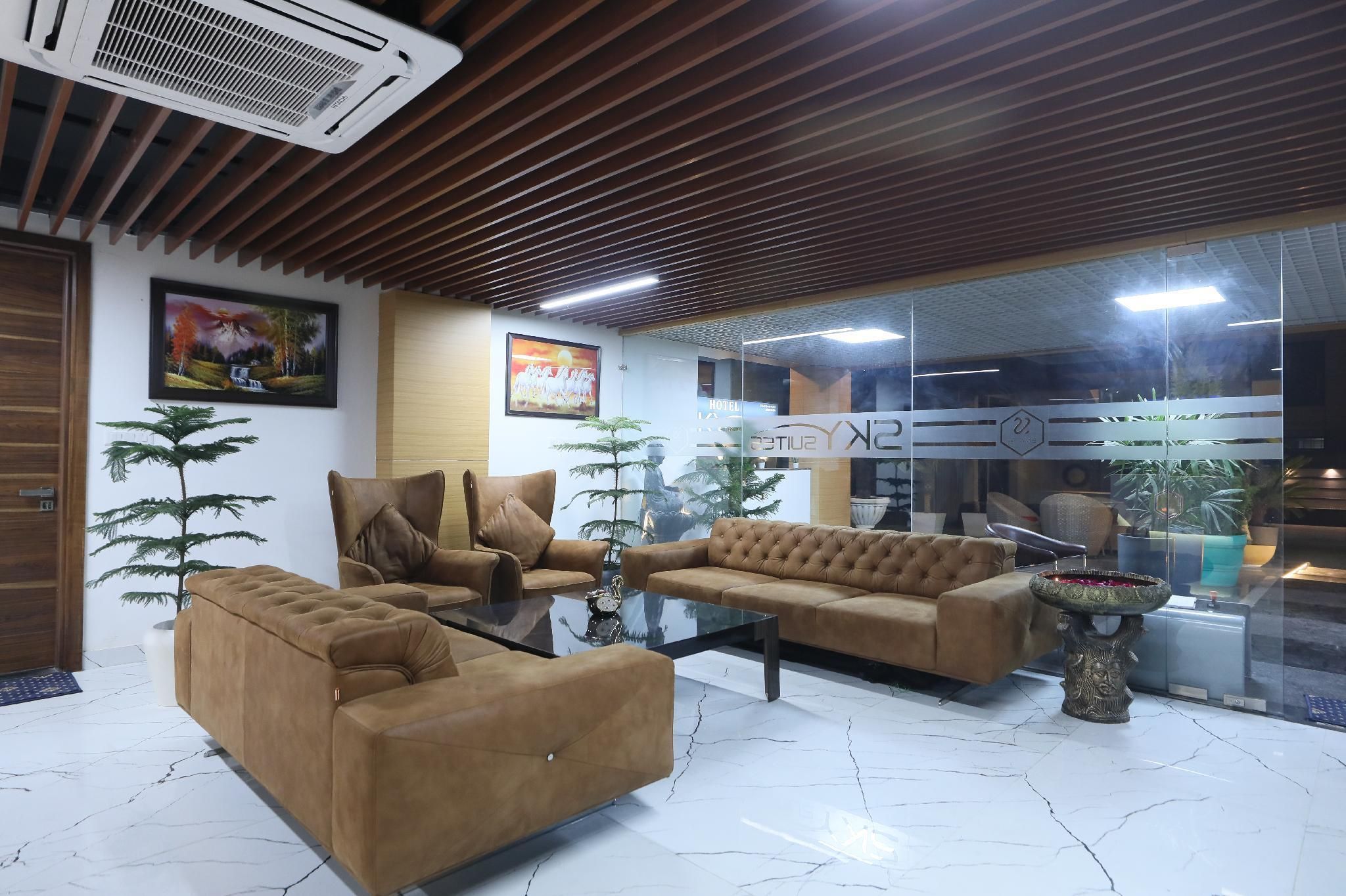 A modern interior with a sofa set, a glass partition, and a decorative fountain.