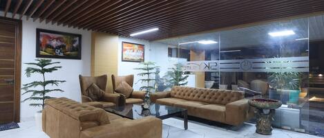 A modern interior with a sofa set, a glass partition, and a decorative fountain.