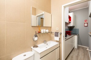 Een badkamer met toilet, wastafel, spiegel en handdoekhouder.