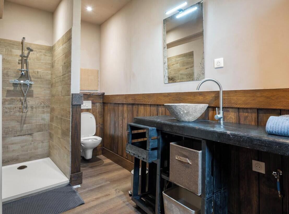Une salle de bain équipée d’une douche, de toilettes et d’un lavabo avec un grand bac.