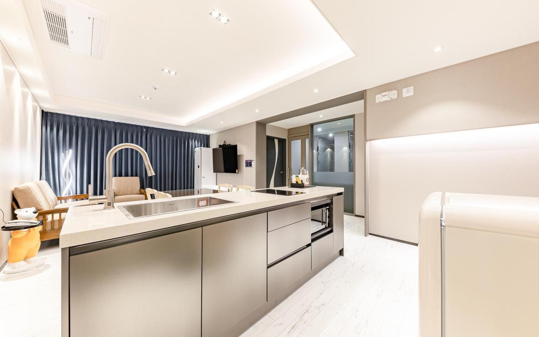 A modern kitchen with a central island, built-in appliances, and a dining area with a view.