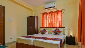A hotel room with a bed, an air conditioner, a wardrobe, and a nightstand. - Collection O 81451 Capital Casa (Barasat)