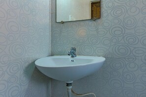 A white sink with a single faucet, a mirror above it, and a patterned wall. - Collection O 81451 Capital Casa (Barasat)