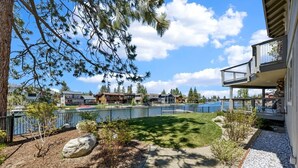 Asuinalue, josta on näkymä järvelle, jossa on aidattu piha ja rakennus, jossa on parveke.