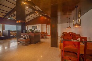A spacious lobby with a high ceiling, wooden furniture, and pendant lighting. - Palri Boutique Hotel (Gangtok)