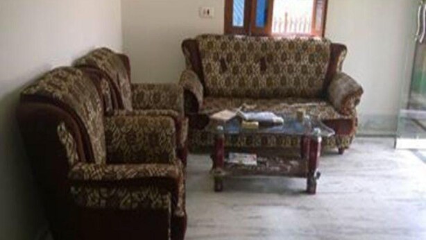 A living room with two patterned sofas and a coffee table. - Rama Guest House (Gaya)