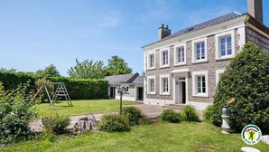 A two-story house with a stone facade, a front door, and a small porch. - Gîtes de France® - L'Orée D'Etretat (LA POTERIE CAP D'ANTIFER)
