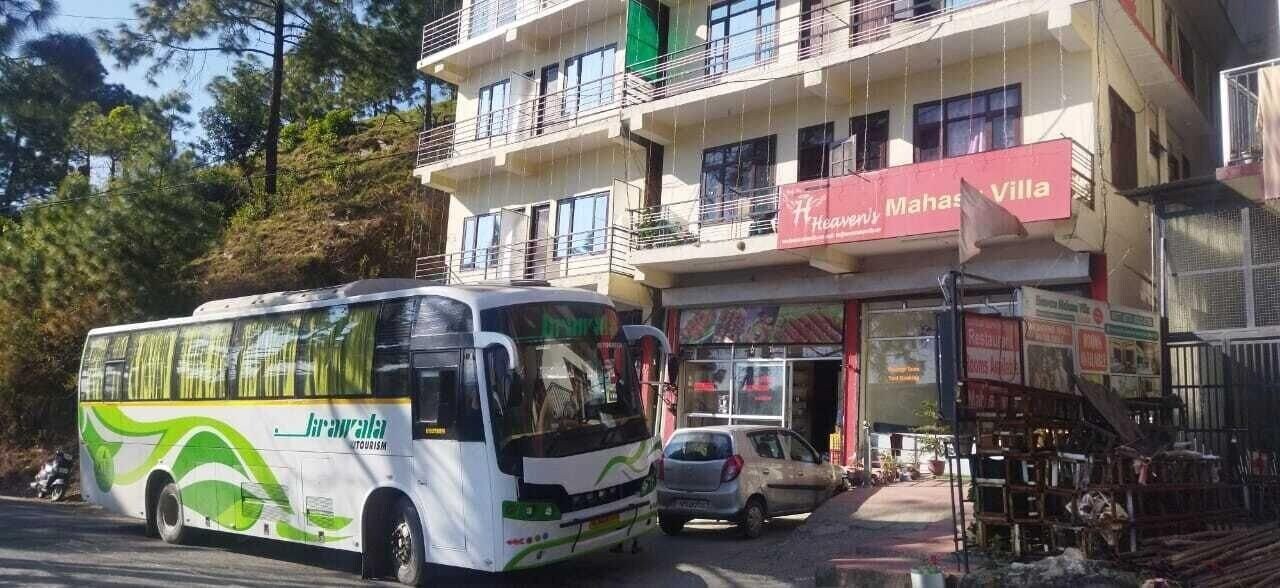 Un autobús estacionado frente a un edificio con un letrero que dice 'Heaven's Mahas Villa'.