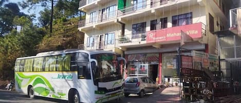 Un autobús estacionado frente a un edificio con un letrero que dice 'Heaven's Mahas Villa'.