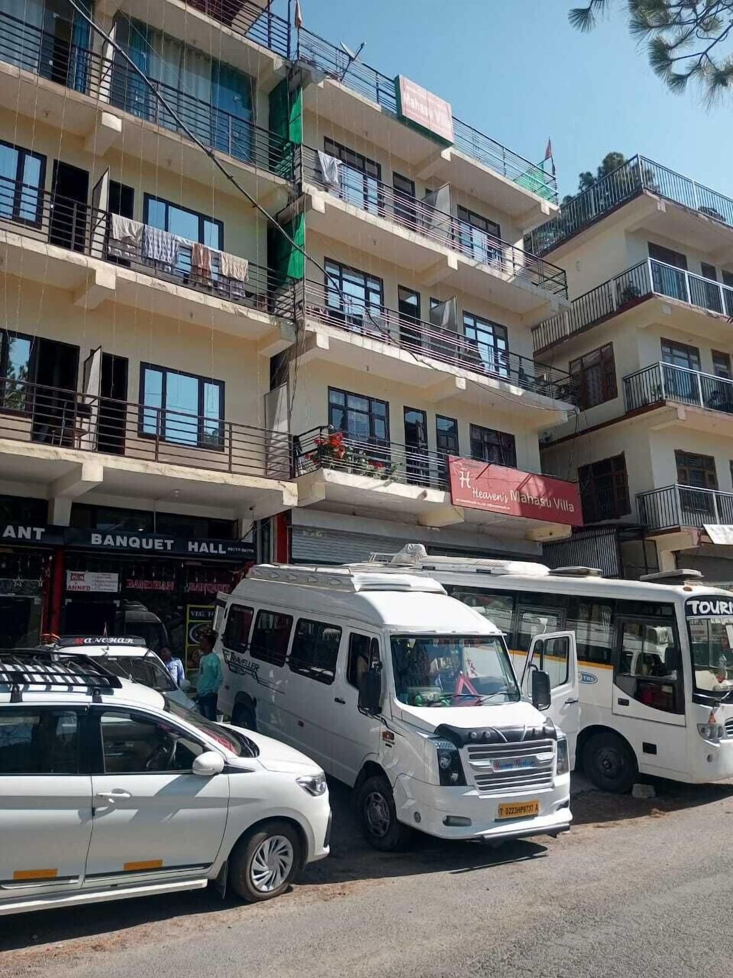 A multi-story building with balconies, a sign for 'Mahasu Villa,' and a 'Banquet Hall' sign.