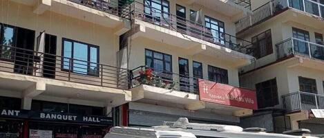 A multi-story building with balconies, a sign for 'Mahasu Villa,' and a 'Banquet Hall' sign.
