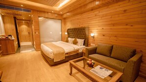 Quarto com piso de madeira, uma cama, um sofá e uma mesa de centro.
