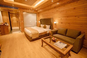 Una stanza con pavimento in legno, un letto, un divano e un tavolino.