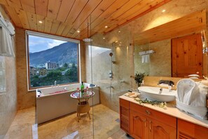 A modern bathroom with a bathtub, a shower, a sink, and a large mirror. - Tiaraa Hotels & Resorts - Manali (Manali)