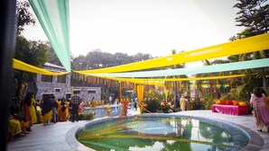 Uma área de piscina ao ar livre com um edifício de pedra ao fundo.