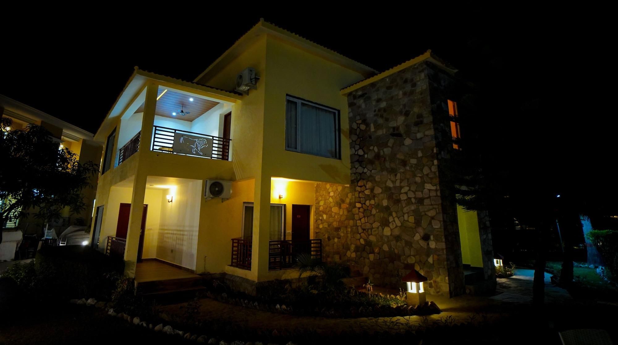 A two-story building with a balcony, a stone facade, and a well-lit entrance.