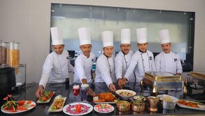 A group of chefs in a kitchen with various dishes and cooking equipment.