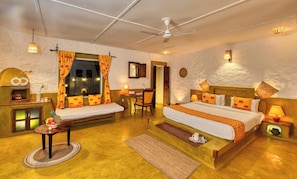 Une chambre d’hôtel confortable, équipée d’un lit, d’un bureau, d’une chaise et d’une petite table avec une lampe.