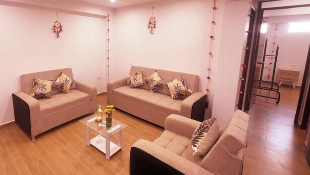 A living room with two sofas, a coffee table, and a small table with flowers. - APARTMENTS ALEXIA HOUSE ENJOY A COMFORTABLE AND COZY STAY IN CUSCO (Cusco)