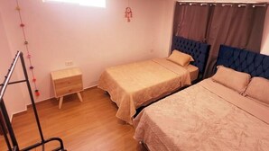 A room with two beds, a small wooden nightstand, a ladder, and a window with curtains. - APARTMENTS ALEXIA HOUSE ENJOY A COMFORTABLE AND COZY STAY IN CUSCO (Cusco)