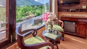 Ein Zimmer mit Bergblick, ein Esstisch mit Speisekarte und ein an der Wand befestigter Fernseher.