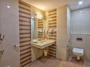 A bathroom with a sink, mirror, towel dispenser, and toilet. - Katoch Grand By Vivaan (Manali)