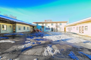 Ein Motel mit einem zentralen Gebäude, auf dem 'Motel' steht, und einem gepflasterten Innenhof.