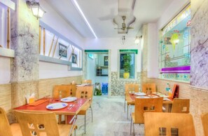 A restaurant with marble walls, wooden chairs, and tables set for dining. - Hotel Natraz New Delhi (New Delhi)