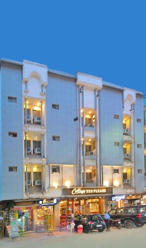 A multi-story building with balconies, a ground-level shop, and a sign reading 'Cottage YES PLEASE'. - Hotel Natraz New Delhi (New Delhi)