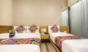 A hotel room with two beds, a nightstand, a mirror, and a window with curtains. - Fabexpress Marol Metro (Mumbai)