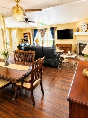 A living room with a dining area, a fireplace, a TV, and a ceiling fan. - Steps to Pine Flat Lake & Marina (Sanger)
