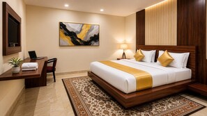 Habitación de hotel con cama, escritorio, silla, lámpara y obras de arte.